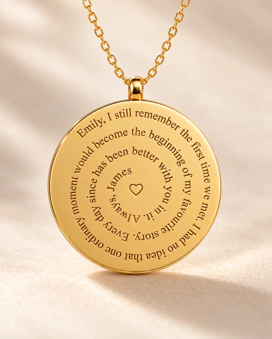 Close-up of the gold pendant back with a spiral message and centre heart